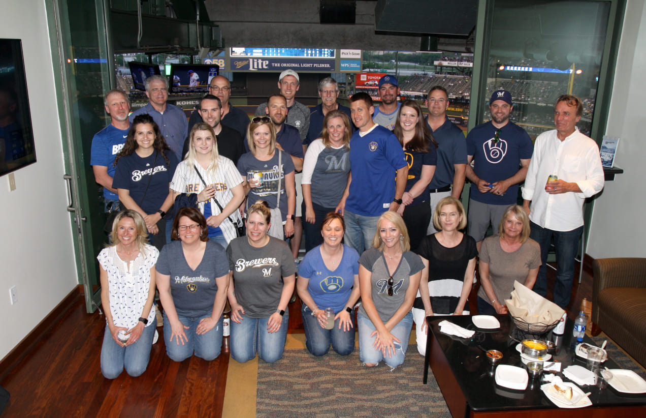 The Investors Associated team poses together at a Milkwaukee Brewers game.