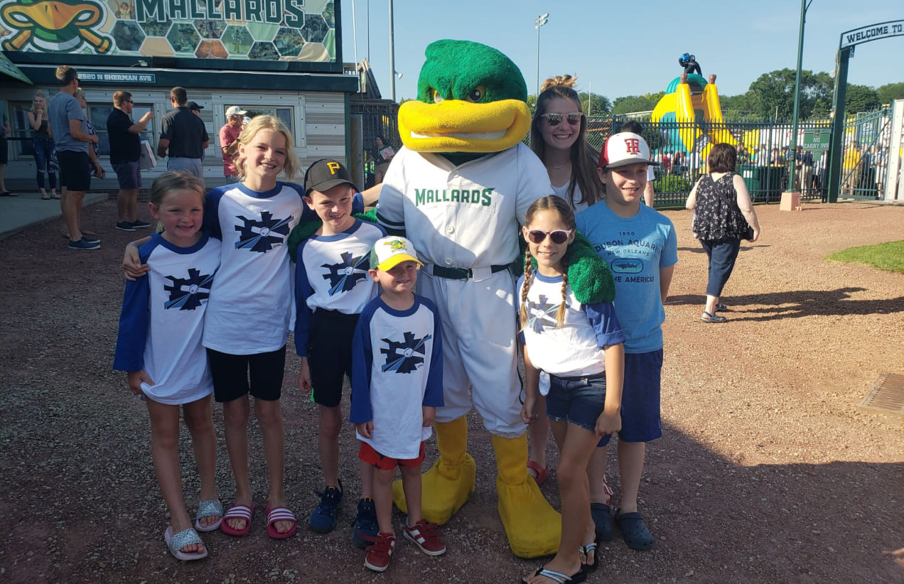 Children of our IA team pose for a photo with the Madison Mallards mascot.