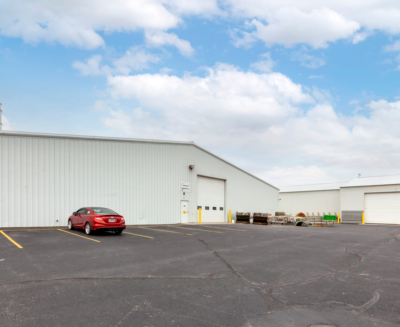 Another view of the back lot and garage doors of the industrial manufacturing building at 865 Stony Road in Lake Mills, WI.
