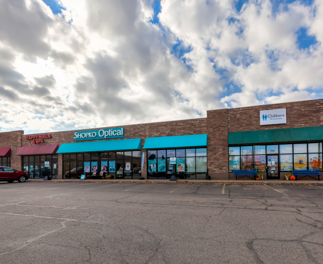The storefronts of Happy Nails & Spa, Shopko Optical, and Children's Wisconsin at 641–725 S. Central Avenue in Marshfield, WI