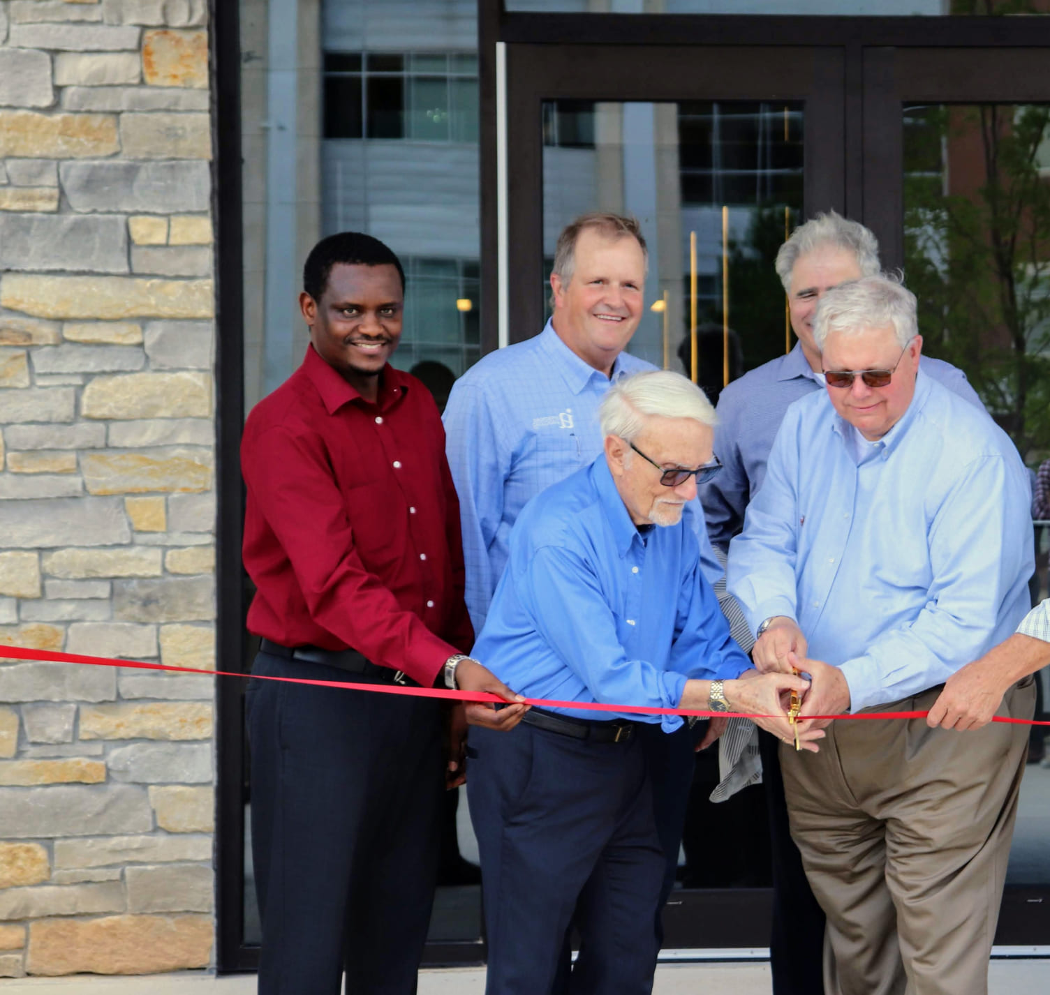 The Investors Associated team cuts a red ribbon at a grand opening.