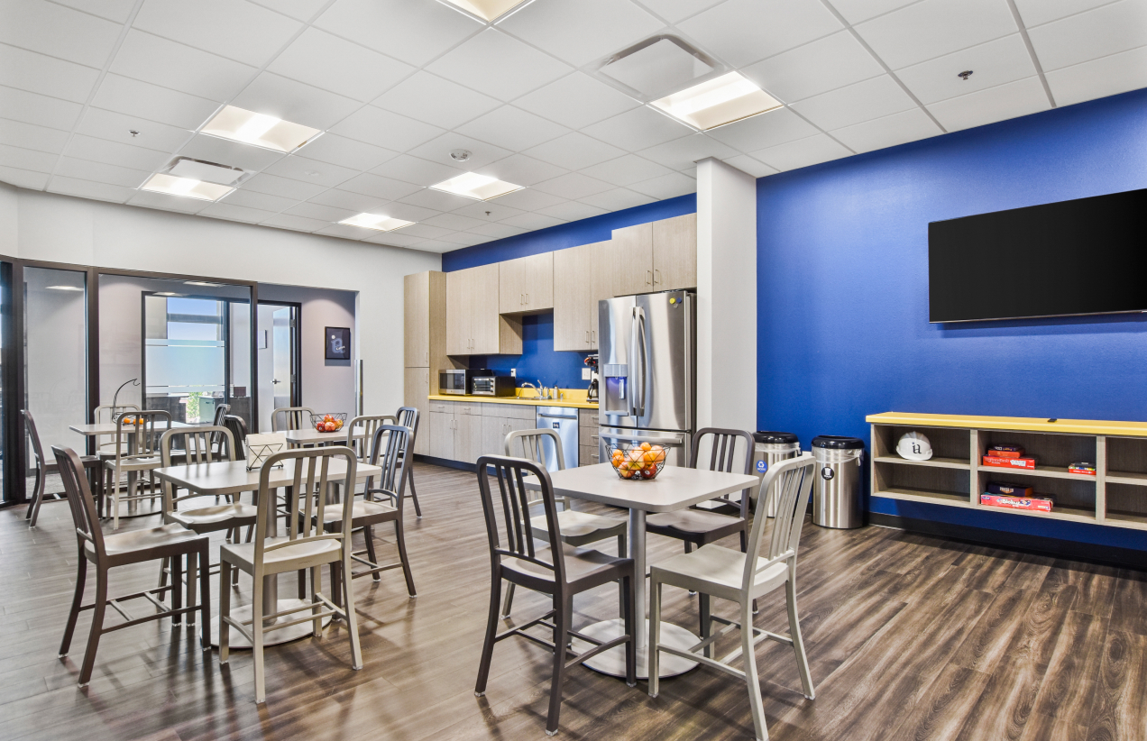 Lunch break room with multiple tables and a large blue wall