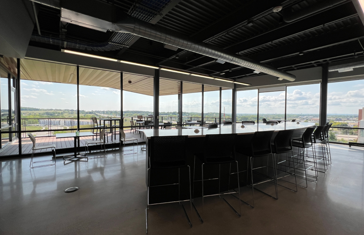 A large space with a long table and chairs overlooking a beautiful view