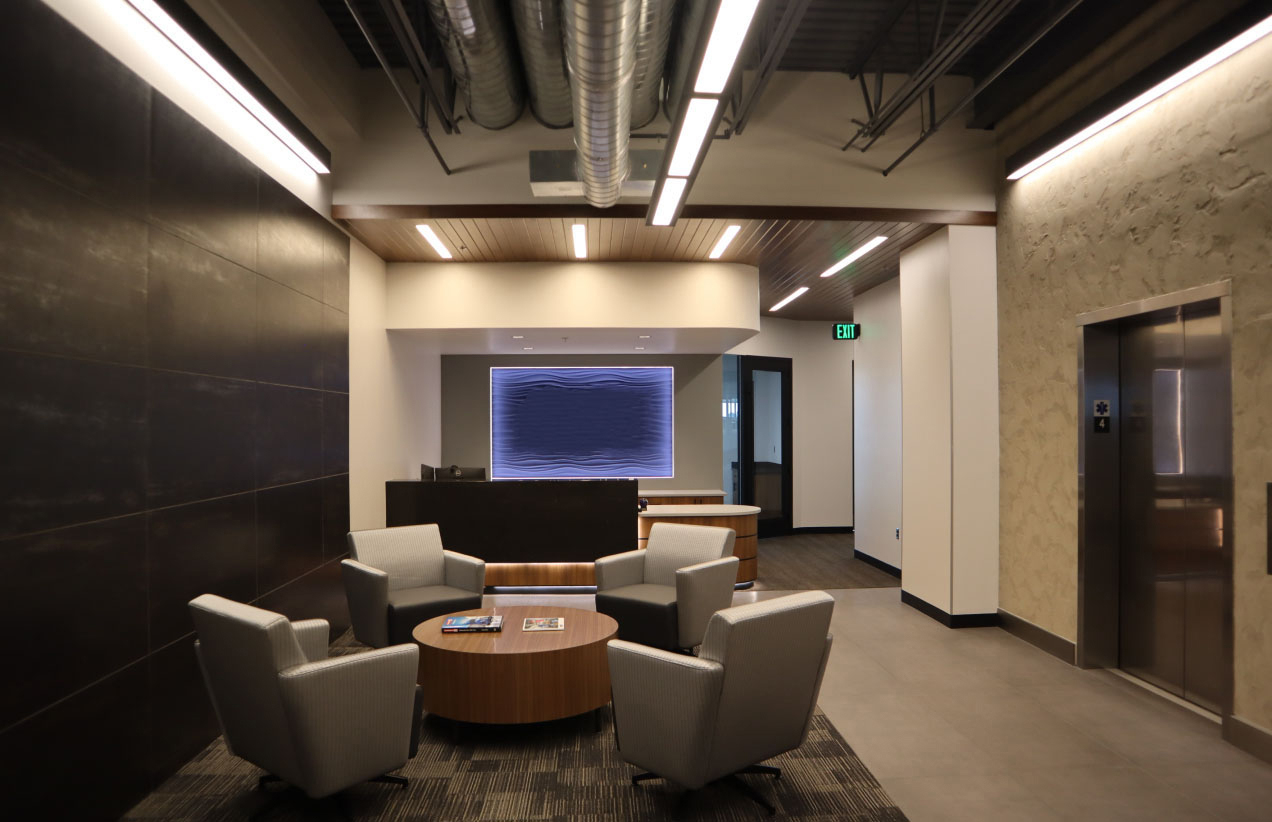 Office lobby showing couches, a tv and an elevator