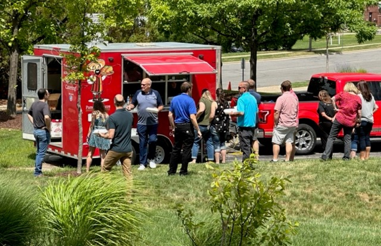 A group of people standing next to a food truck